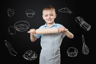 İyimser çocuk annesi için pasta pişirme sırasında bir oklava kullanarak