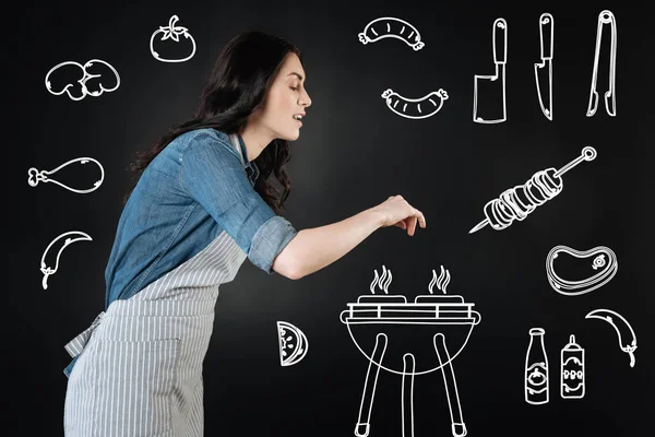 Sorridente giovane donna aggiungendo spezie mentre fa barbecue — Foto Stock
