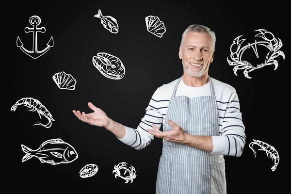 Experienced cook smiling while offering tasty marine food — Stock Photo, Image