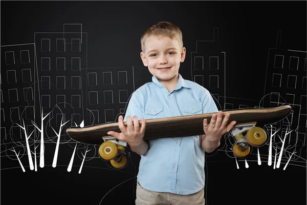 Glückliches Kind, das ein Skateboard hält, bevor es zu seinen Freunden geht — Stockfoto