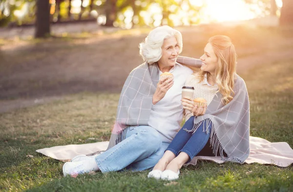 Mulher inteligente desfrutando de conversa com a velha mãe no parque — Fotografia de Stock