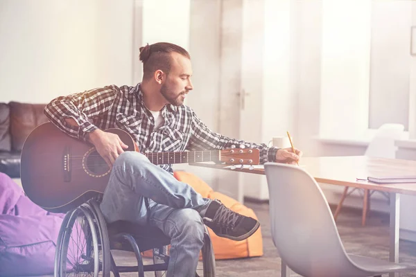 Delighted musician sitting in light room — Stock Photo, Image