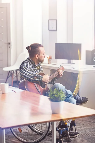 Musiker sitzt zwischen zwei Tischen — Stockfoto