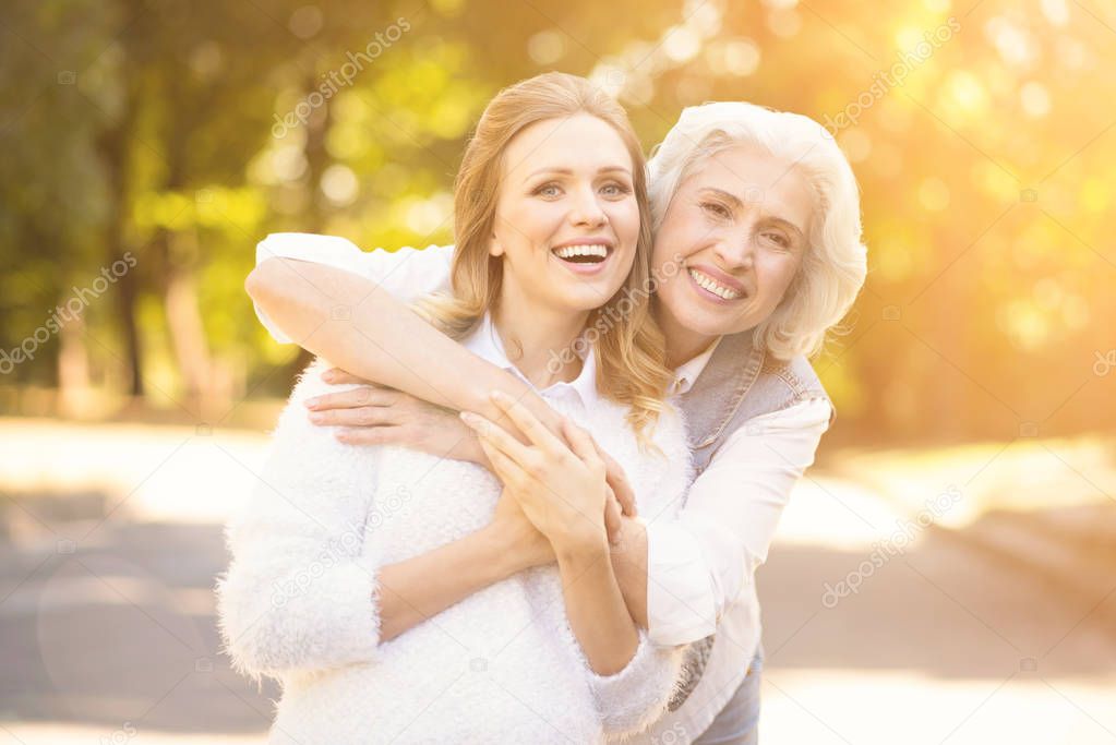 Friendly woman enjoying walk with pensioner in the square