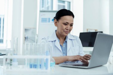 Onun laptop laboratuarda çalışan neşeli araştırmacı