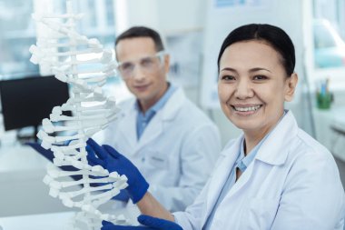 Bir Dna modeli bir laboratuarda holding neşeli Asyalı kadın