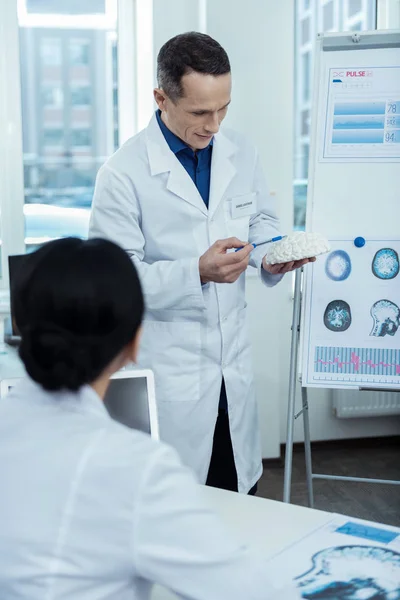 Agradable hombre guapo sosteniendo un modelo de cerebro — Foto de Stock