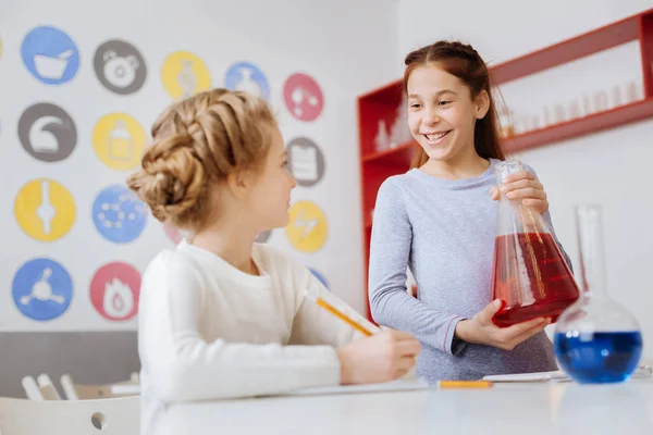 Chica optimista charlando con su amigo durante la clase de química —  Fotos de Stock