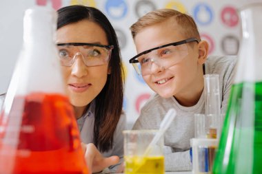 Neşeli öğrenci ve onun öğretmen izlerken kimyasal tepki birlikte