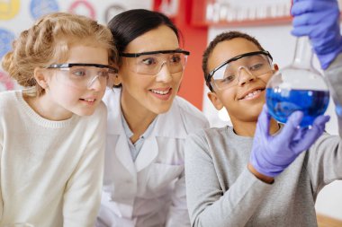 Okul çocuğu gösteren şişesi gururla öğretmeni ve sınıf arkadaşı için madde ile