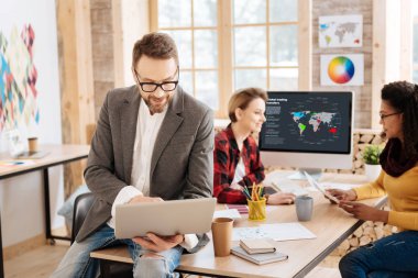 Onun laptop ofiste çalışan gülümseyen adam