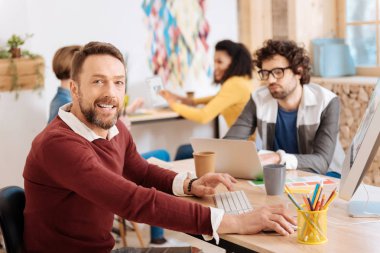 Gülümseyen adam ofiste meslektaşları ile çalışma