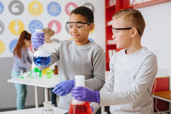 Upbeat studenter hålla kolvar med rykande ämnen — Stockfoto