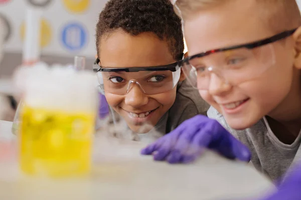 Primer plano de dos compañeros de clase observando la reacción química —  Fotos de Stock