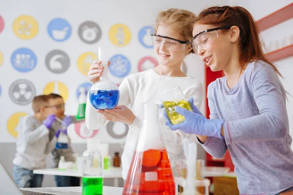 Optimistische Schulmädchen überprüfen die gewünschte chemische Reaktion im Kolben — Stockfoto