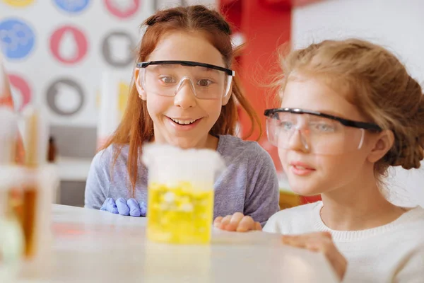 Duman kimyasal şişesi çıkıyor izlerken neşeli kız öğrenciler — Stok fotoğraf