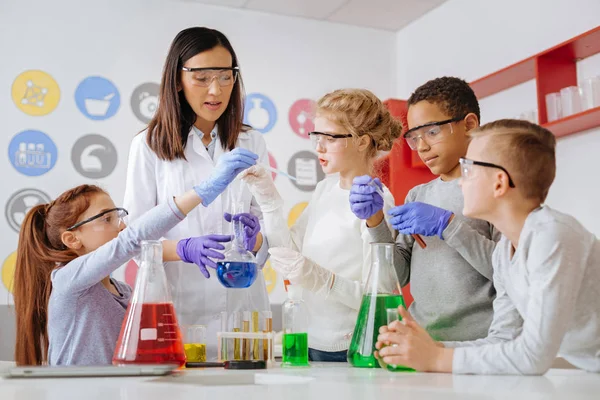 Grupo de estudiantes y su profesor realizando experimentos químicos — Foto de Stock