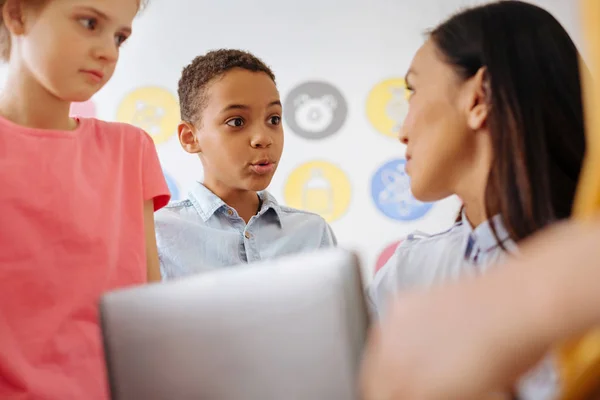 Lindo chico comunicándose con su maestro después de la clase — Foto de Stock