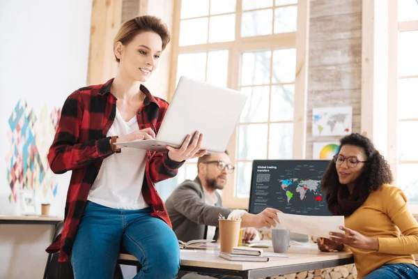 Mujer sonriente trabajando en la oficina con sus compañeros de trabajo — Foto de Stock