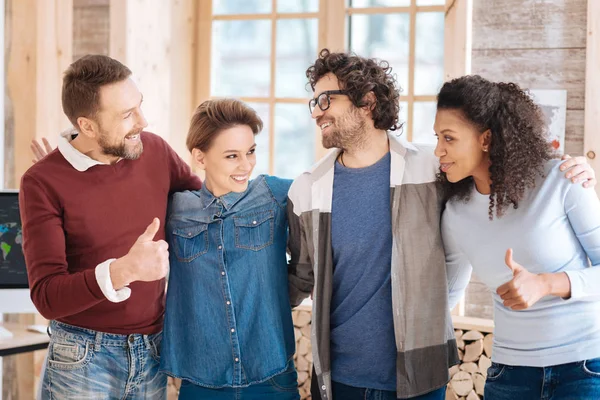 Empleados inspirados sonriendo y abrazando — Foto de Stock