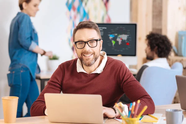 Souriant homme travaillant sur son ordinateur portable — Photo