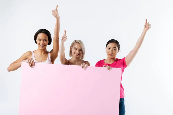 Alegre mujeres jóvenes mostrando pulgares hacia arriba signos — Foto de Stock