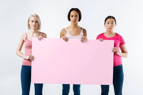 Vážnou mladé ženy stojící proti Bílému pozadí — Stock fotografie