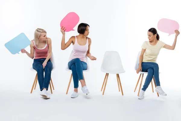 Mulheres jovens positivas olhando para a cadeira — Fotografia de Stock