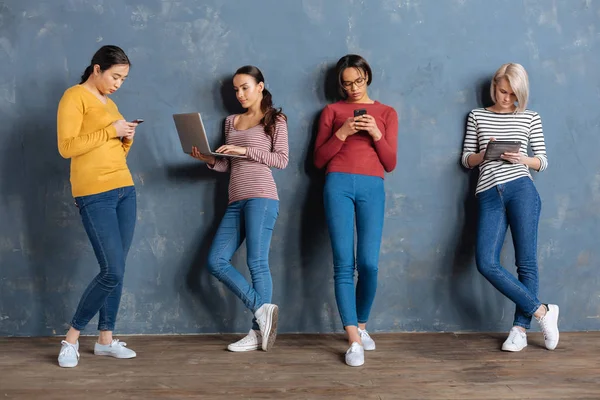 Serious young women leaning to the wall