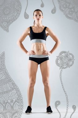 Elleri kalça üzerinde duran ve sakin seyir fitness eğitmeni