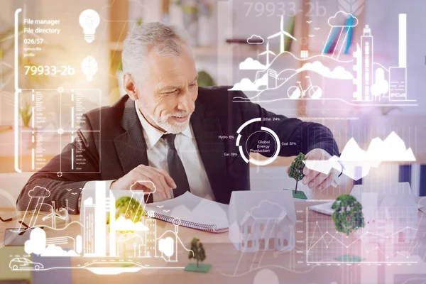 Careful architect smiling while holding a tiny tree — Stock Photo, Image