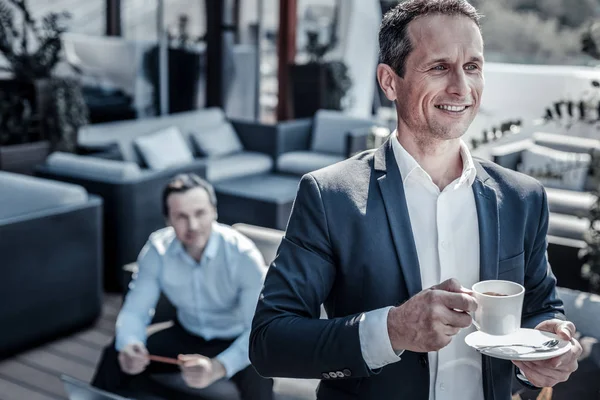 Glad positiv affärsman som håller en kopp — Stockfoto