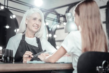 Manikür salonda çalışan memnun yaşlı kadın