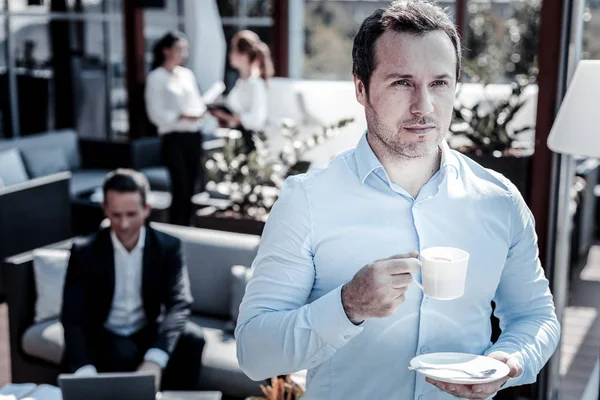 Serious self employed man holding a coffee cup — Stock Photo, Image