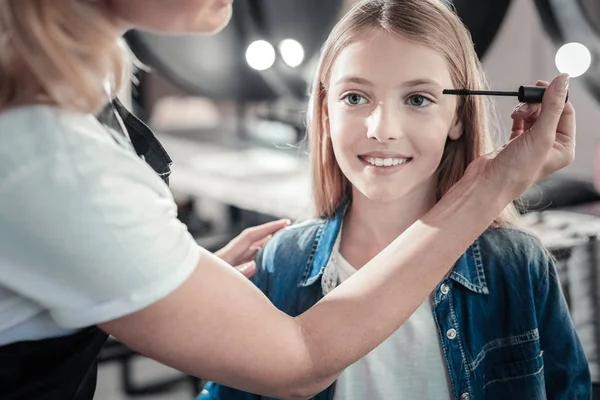 Happy young girl having her eyelashes painted — Stock Photo, Image