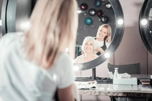 Happy elderly woman looking into the mirror — Stock Photo, Image