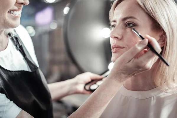 Nice young woman having her eye makeup done — Stock Photo, Image