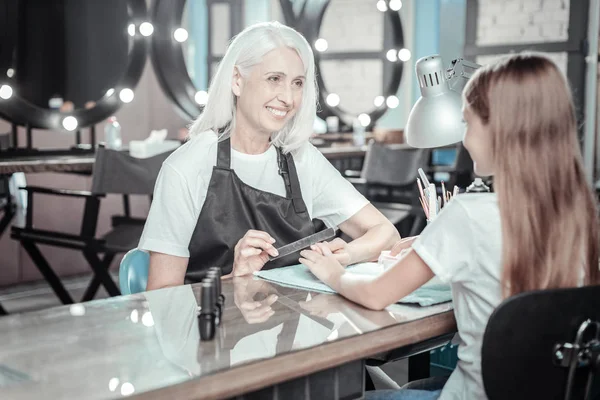 Mujer encantada positiva limar las uñas — Foto de Stock