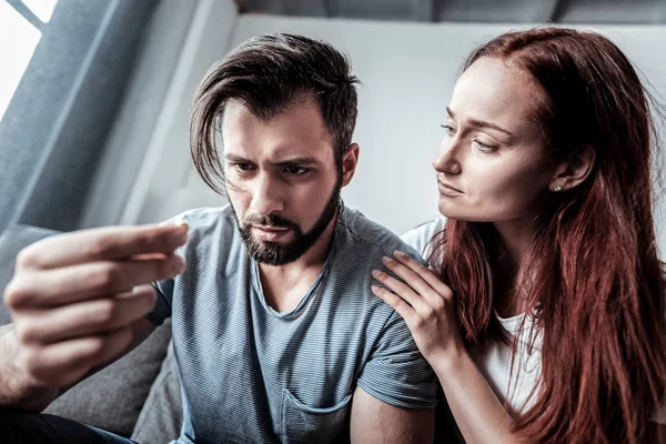 Sad gloomy woman touching her boyfriends shoulder