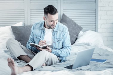Dizüstü bilgisayar ekranına bakarak olumlu yakışıklı adam