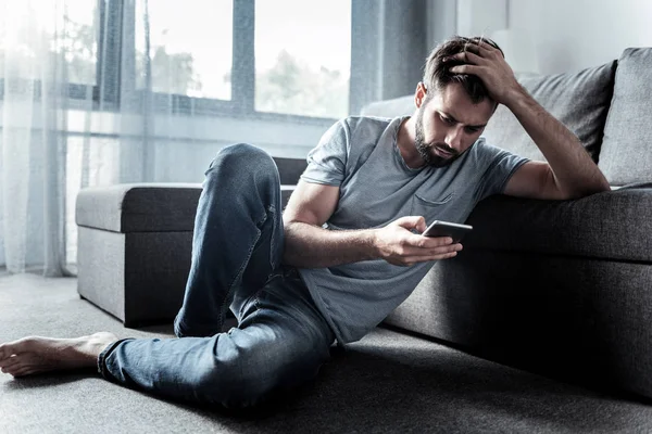 Bonito hombre malhumorado revisando sus mensajes —  Fotos de Stock