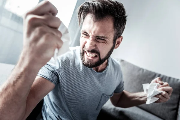 Irritado jovem homem crumpling papel — Fotografia de Stock