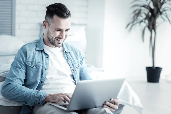 Alegre homem positivo olhando para a tela do laptop — Fotografia de Stock