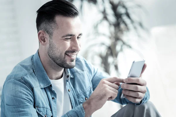 Hombre positivo encantado usando su teléfono inteligente —  Fotos de Stock