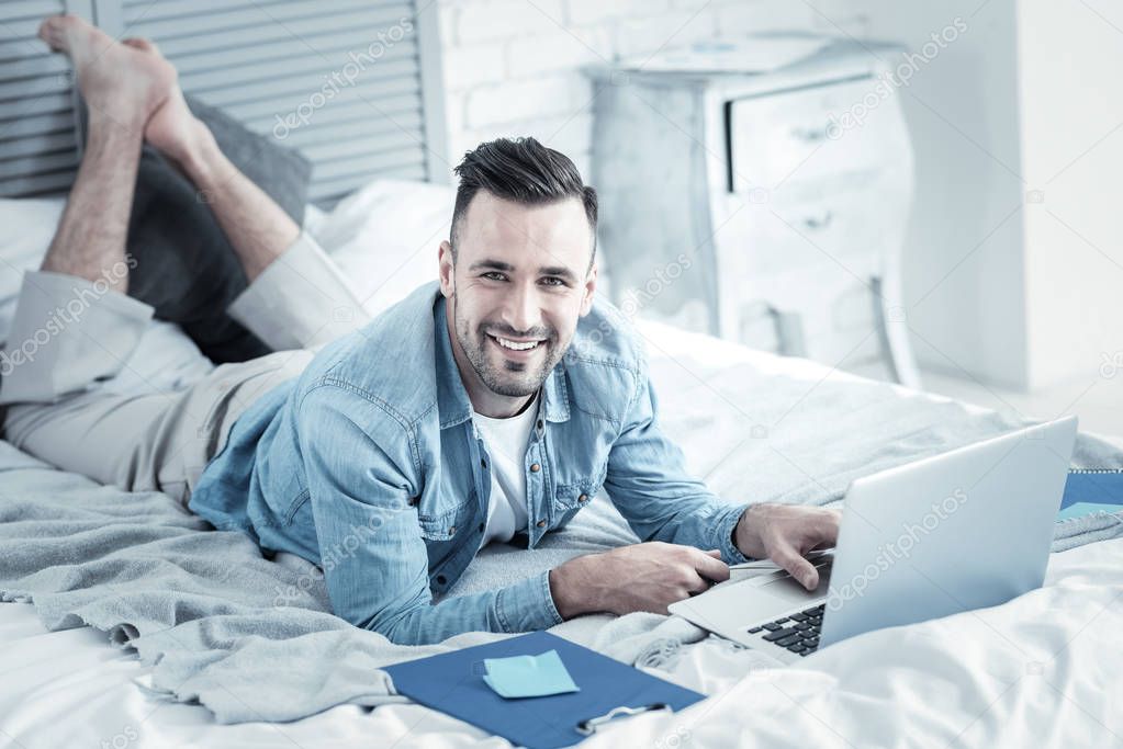 Cheerful handsome man doing an online course