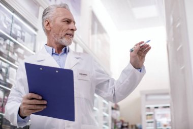 Kendine güvenen erkek eczacı kontrol sunar