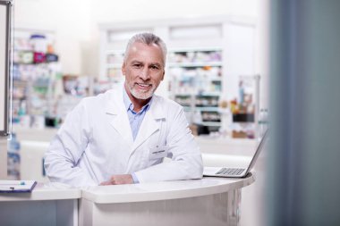 İstemci için bekleyen neşeli erkek eczacı