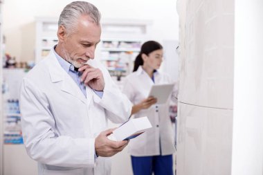 Düşünceli erkek eczacı tıbbi ürünler izleme