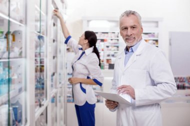 Neşeli erkek eczacı elektronik sistemiyle