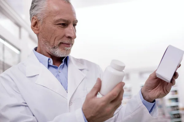 Рефлекторний чоловічий фармацевт, що перевіряє ліки — стокове фото
